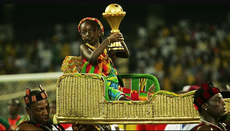 afcon trophy held by a little girl seated in a palanquin and carried by men