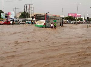 Bus and people wading through flood in Accra