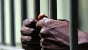 Prisoner's hands on a prison door