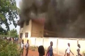 Fire burning a dormitory block at Tolon SHS while students walk by