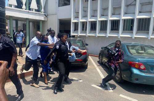Police carrying the Aisha Huang's collapsed accomplice