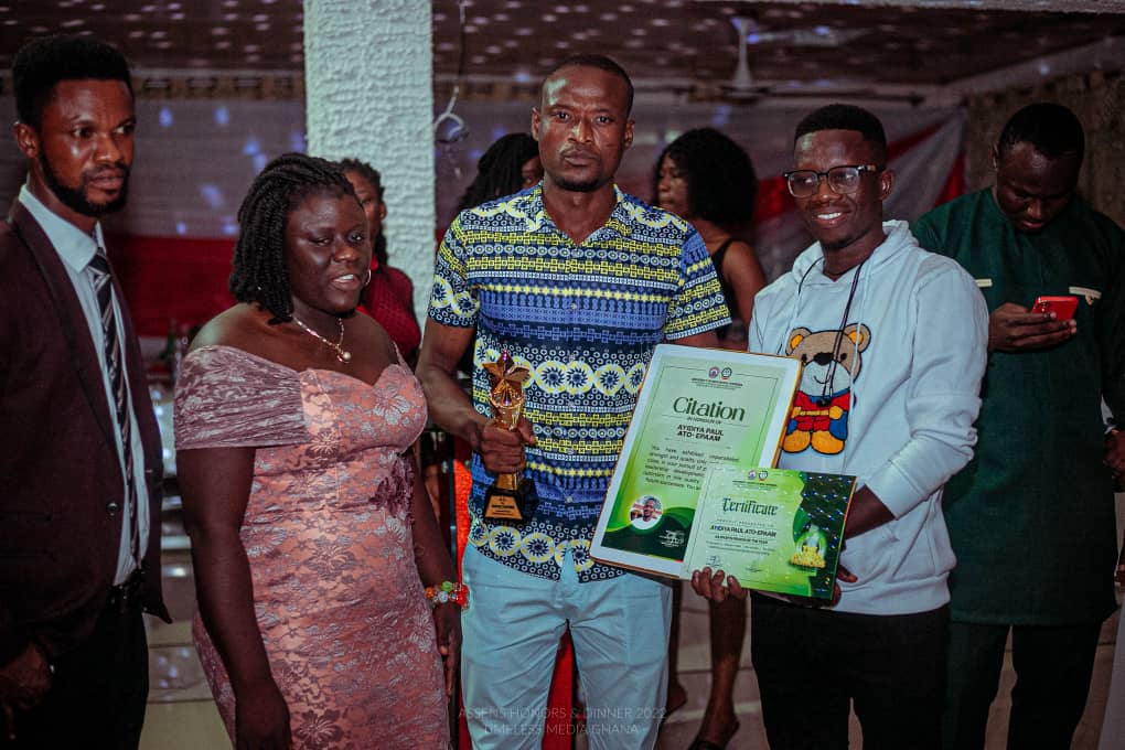 Paul Ayidiya holding the trophy and citations